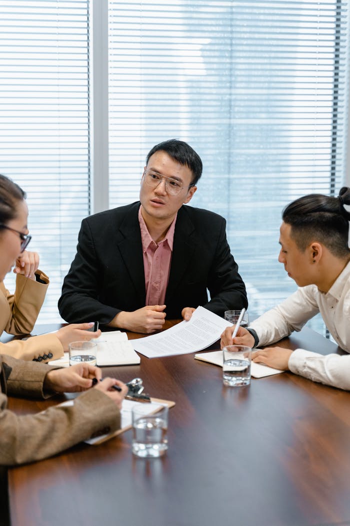 Team of professionals collaborating during a business meeting in a modern office setting.